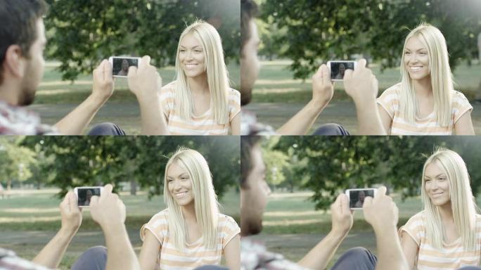 男子用手机给女友拍照