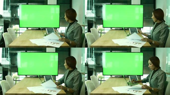 女商人在电视上开会和视频会议监视器绿色屏幕