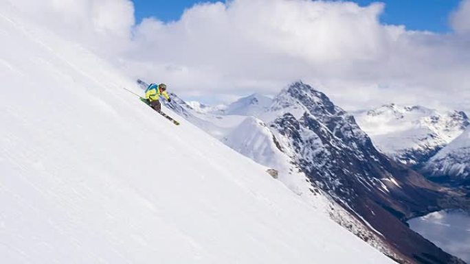 自由式滑雪者滑雪粉雪，背景为峡湾