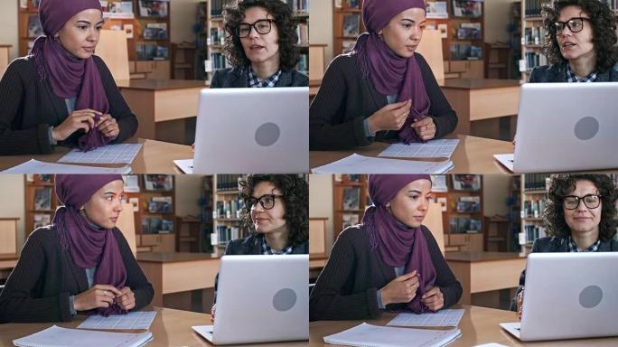 年轻的穆斯林妇女与女老师一起学习