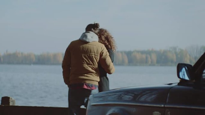 年轻夫妇在湖边拥抱