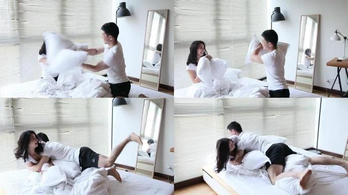 一对夫妇在床上玩枕头大战