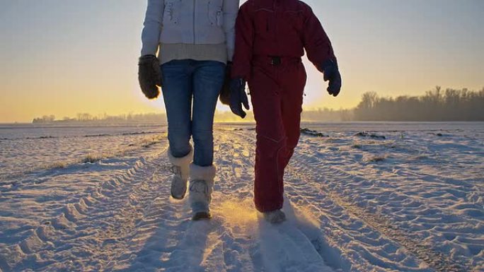 远景：母亲和女儿在雪地里行走