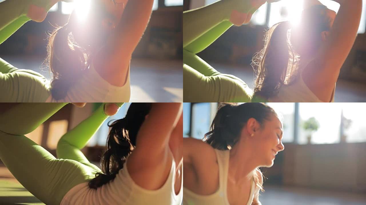 一位迷人的女教练在瑜伽工作室的垫子上做体式