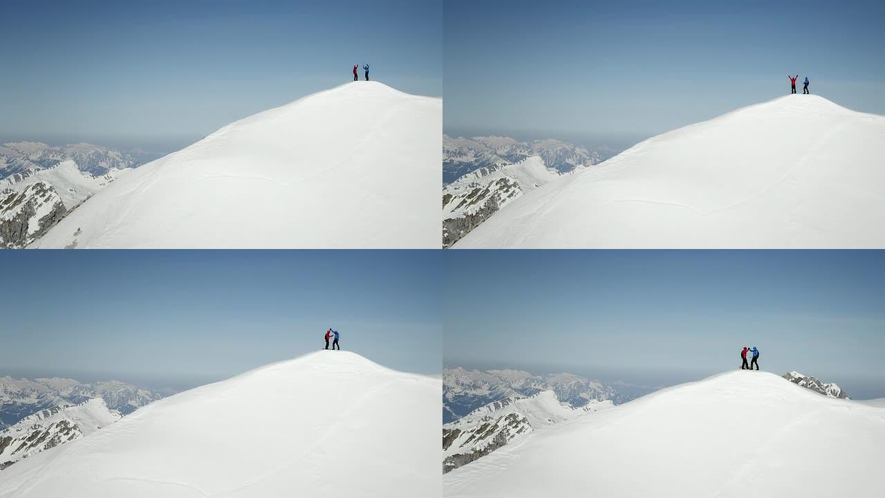 登山者在白雪覆盖的山峰上欢呼雀跃