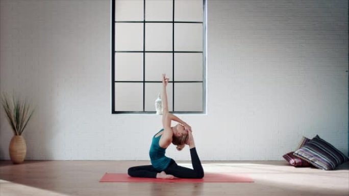 在健身房练习瑜伽的女人 (鸽子姿势)