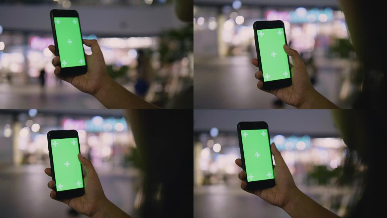 女人在街上使用带有绿屏的智能手机