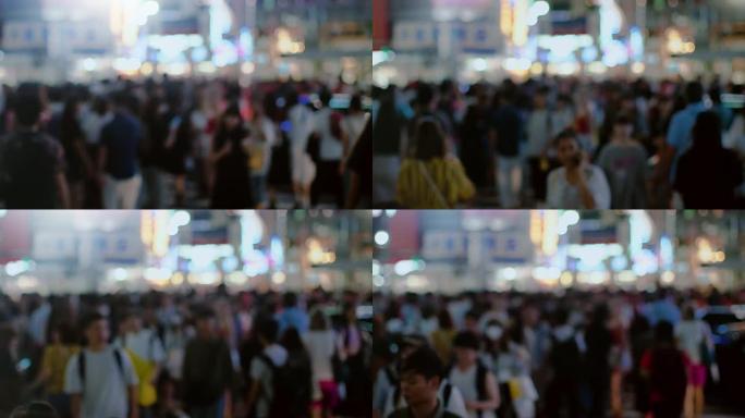 一大群人在背景中明亮的大城市灯光下行走的镜头。