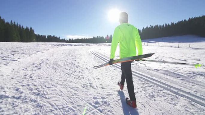 在雪地上行走的年轻男子越野滑雪运动员