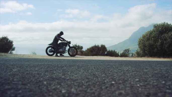 男子在山路上骑摩托车