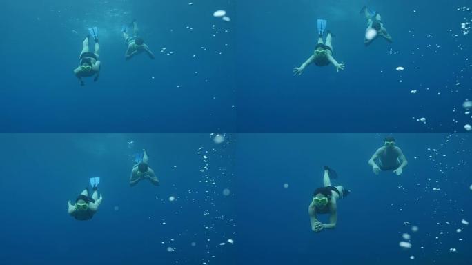 情侣向相机游泳的水下镜头