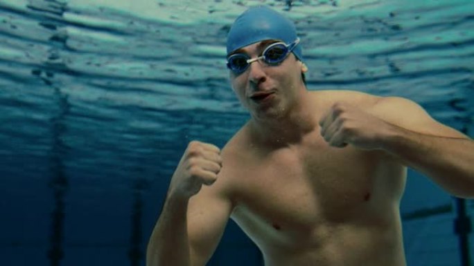 年轻的男游泳运动员微笑着竖起大拇指