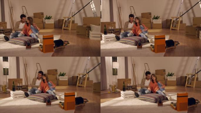 一对夫妇坐在新公寓的地板上