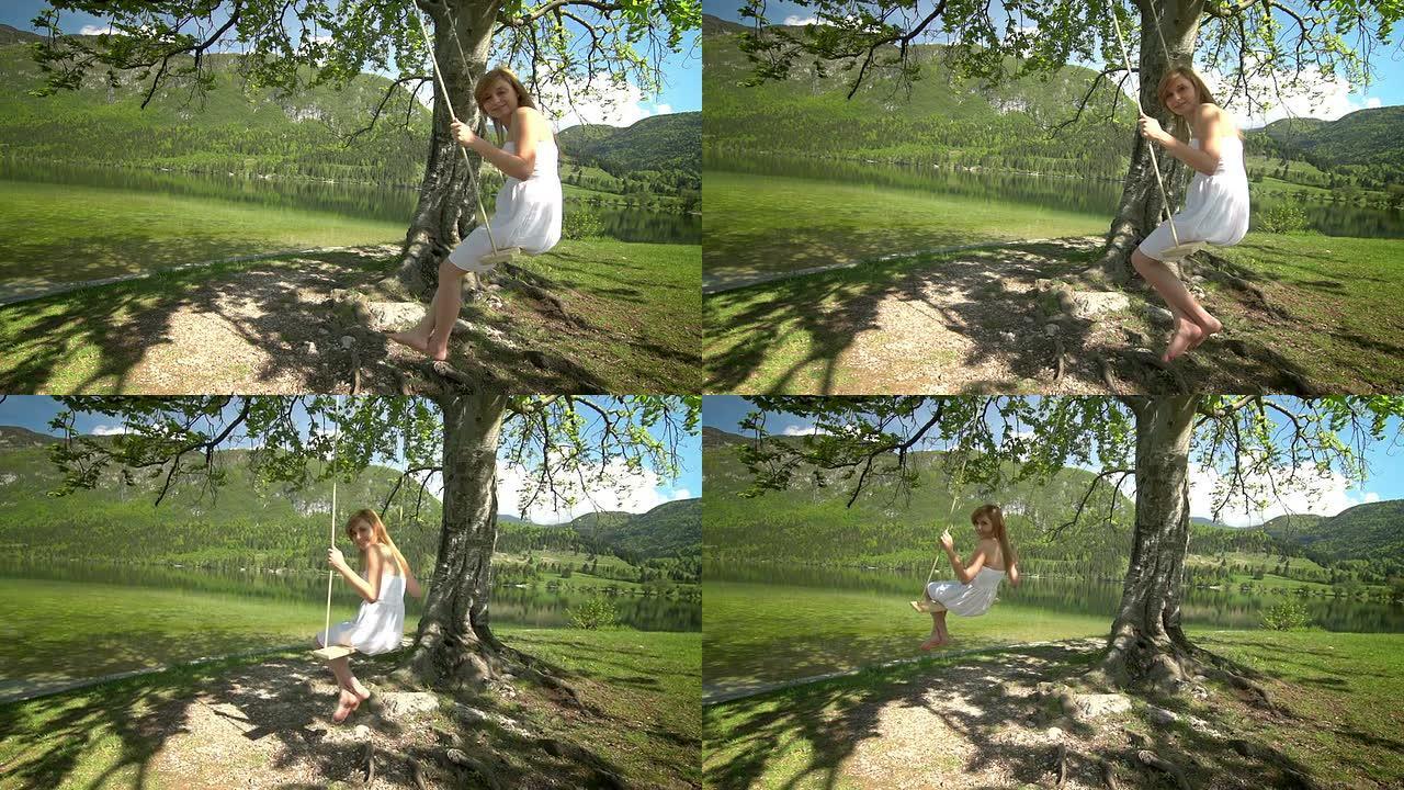 一个穿着白色连衣裙的女孩在树下用绳子荡秋千