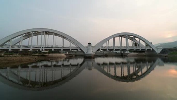 景观和旅行概念，在Lamphun省日落时间与河流反射的Thachompoo桥的4k时间流逝