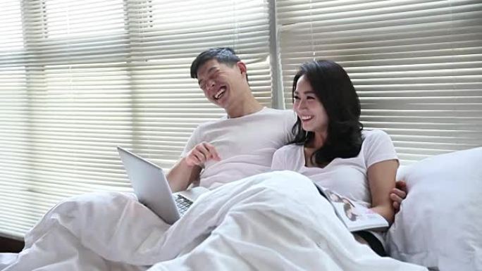 夫妇使用笔记本电脑浏览互联网并互相交谈