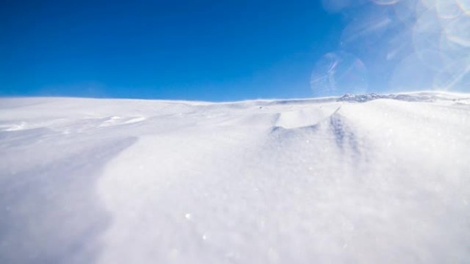 在晴朗的冬日，风吹雪