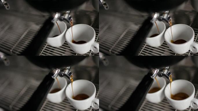 从4k咖啡机倒入两个白色瓷杯中的热浓缩咖啡的超慢动作 (俯视图特写)