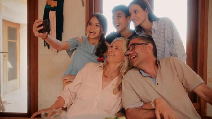幸福的多民族家庭，祖父母在智能手机上自拍