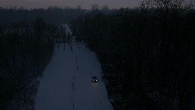 空中汽车在夜间沿着积雪覆盖的乡村道路行驶