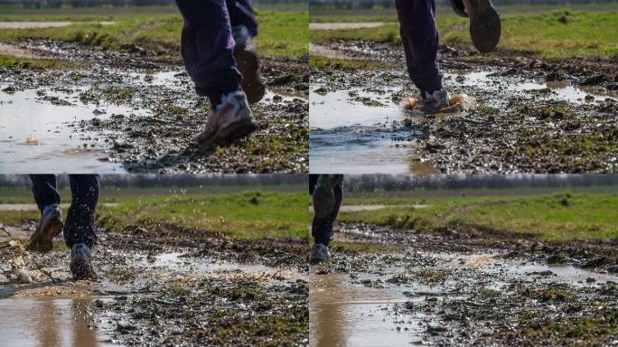 慢动作：一名男子在泥泞的水坑中奔跑