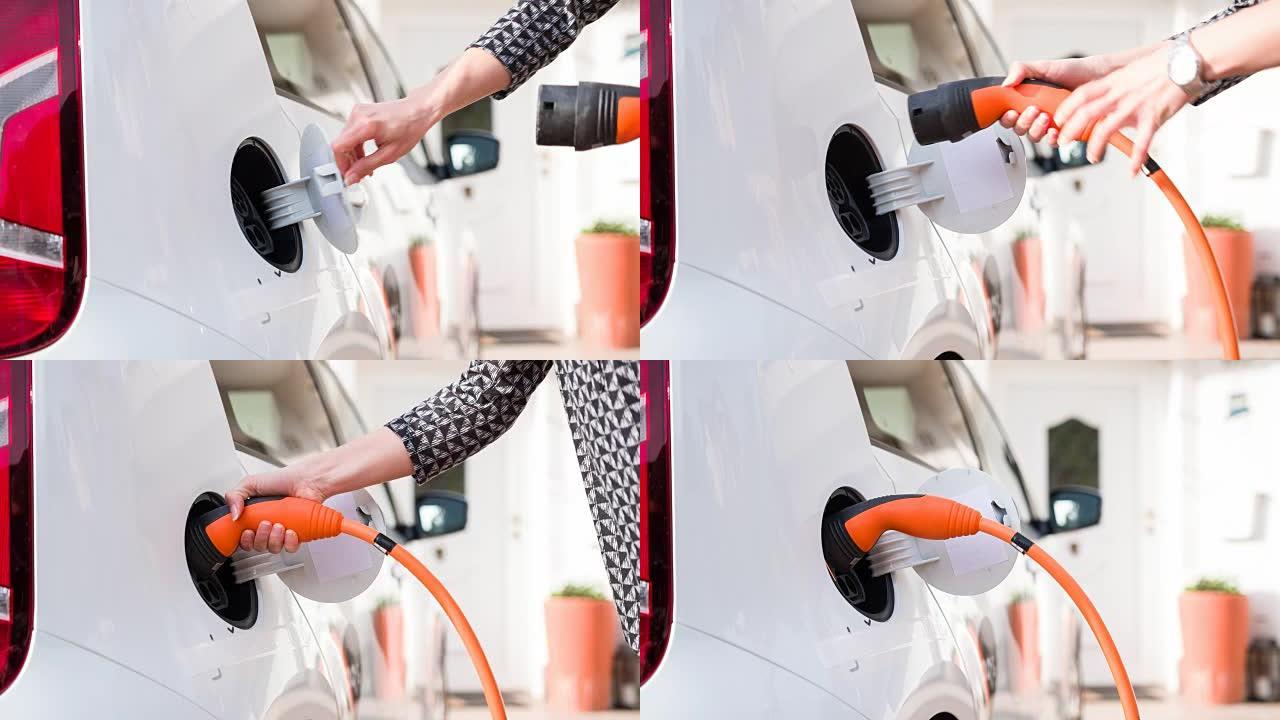 女人将车道上的电动汽车插入家用充电系统以给电池充电