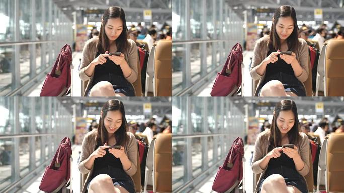 亚洲年轻女子在等待飞行时触摸智能手机，慢动作
