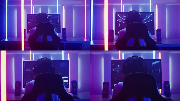 在他的个人电脑上玩第一人称射击游戏在线视频游戏的职业玩家的后视图镜头。复古拱廊风格的霓虹灯点亮的房间