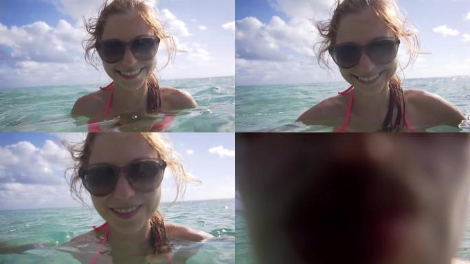 在海中享受的女人亲吻相机