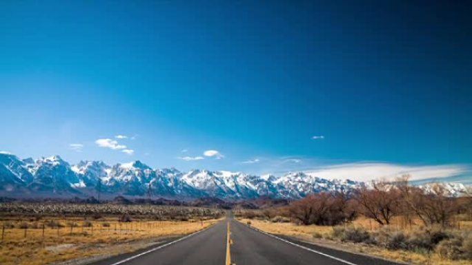 空旷的高速公路在田园诗般的景观中，背景为Sierre内华达山脉，加利福尼亚