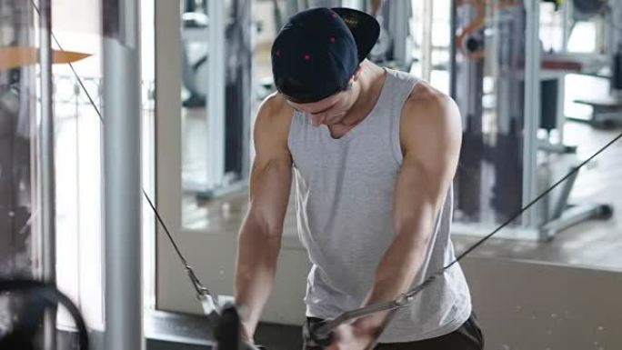 健身房里一个光着膀子的人，训练他的身体保持健康，并有明确的肌肉。运动员举起沉重的重量和乏力。