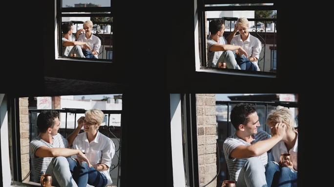 相机接近美丽的年轻浪漫夫妇坐在一起，在一个阳光明媚的小阳台上拥抱和交谈