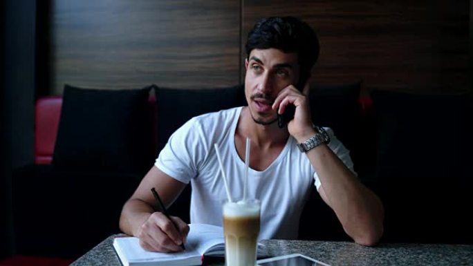 年轻的商人在咖啡馆用智能手机聊天