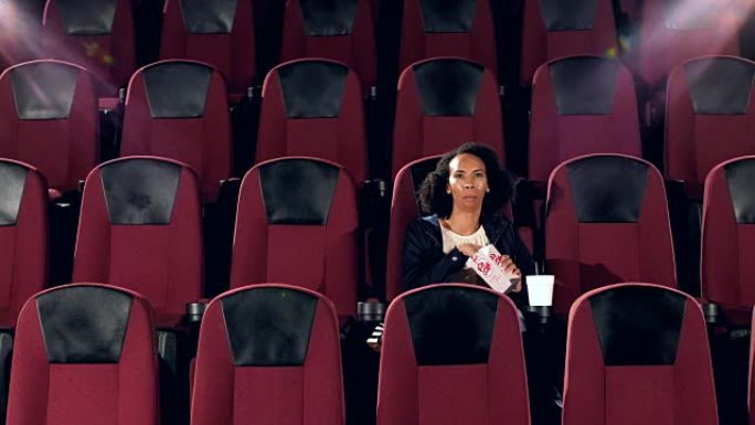 一名非裔美国妇女独自坐在电影院里