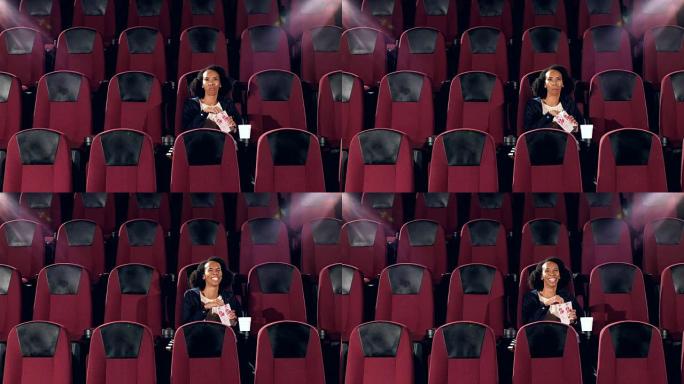 一名非裔美国妇女独自坐在电影院里