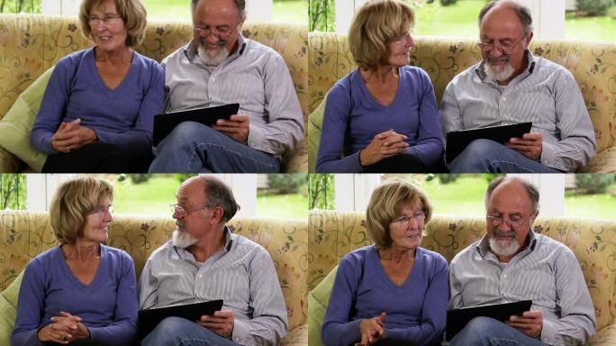 快乐的老年夫妇与数字平板电脑