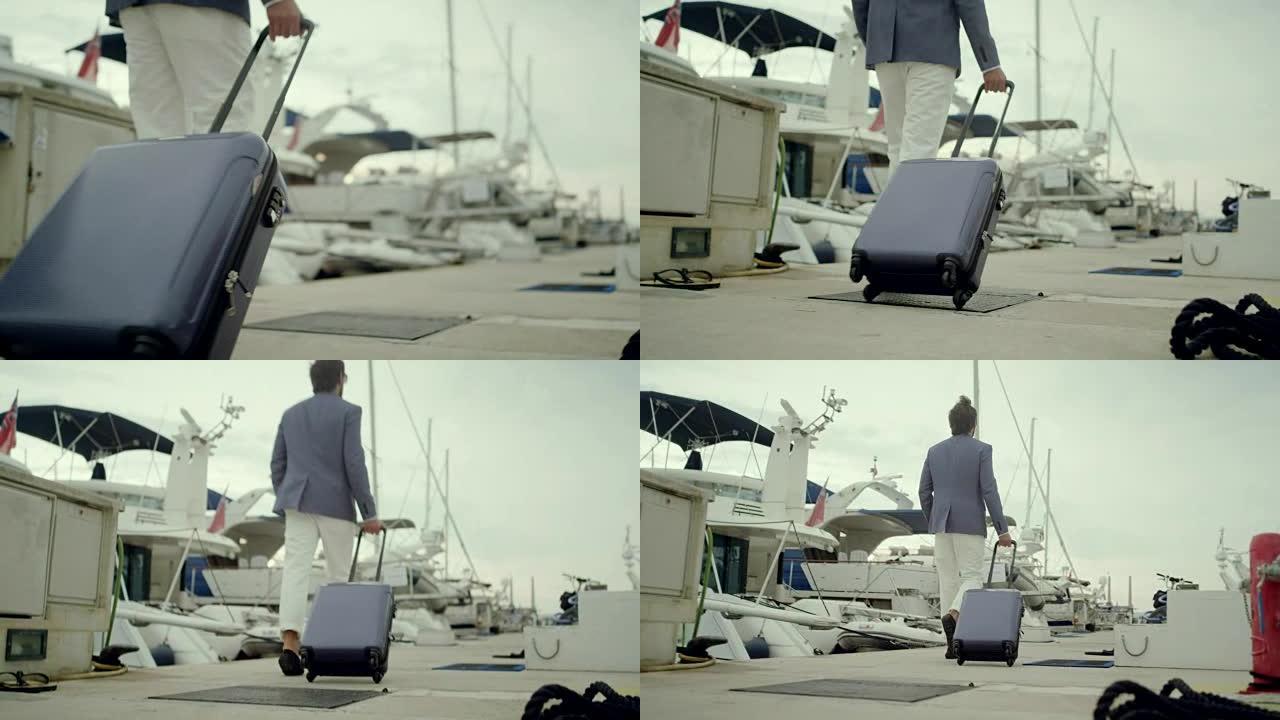 度假的商人。在码头上带着手提箱散步