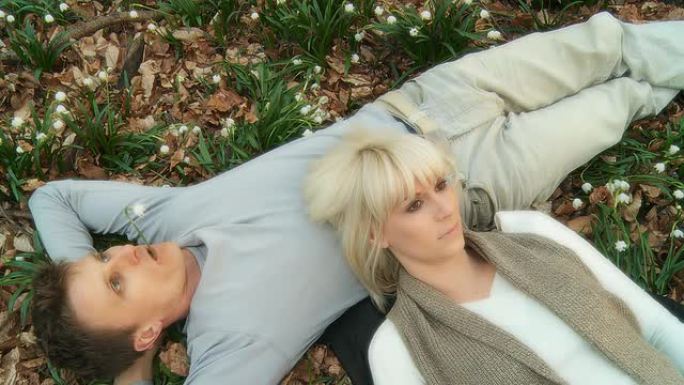 HD：一对年轻夫妇躺在春天的森林里