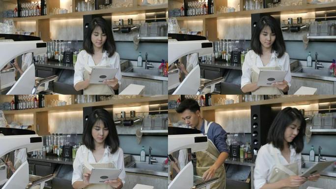 年轻的亚洲咖啡师在咖啡店休息时使用平板电脑