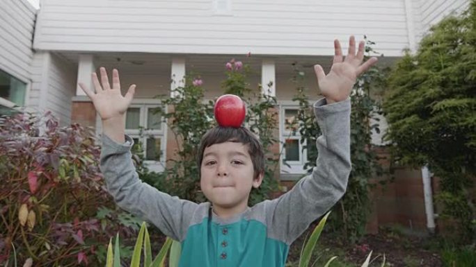 小男孩在头上平衡苹果