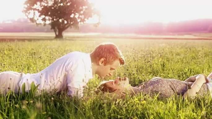 草地上浪漫的年轻夫妇