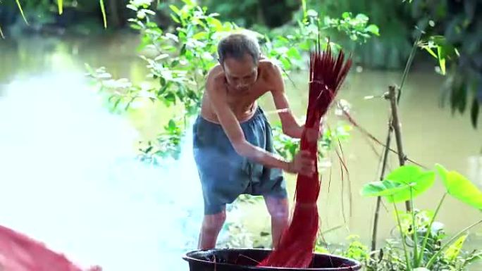 越南老工匠在越南东塔丁延的老传统村庄染上传统越南垫子的4k镜头场景，传统艺术家概念