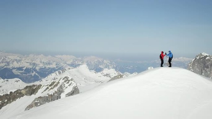 登山者在白雪覆盖的山峰上欢呼雀跃