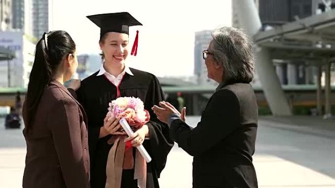 美丽的年轻女毕业生与父母在仪式上。