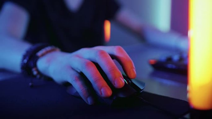 使用电脑鼠标的手的特写。凉爽的霓虹灯复古灯。在互联网上浏览或玩在线游戏。
