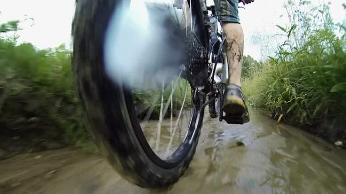 骑着山地自行车穿过潮湿泥泞的小路。