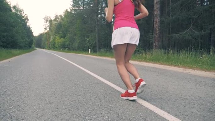 年轻健康的女人在路上奔跑。健康的生活方式理念。