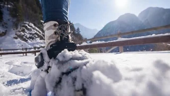 女人在雪山边扫雪雪地雪上行走