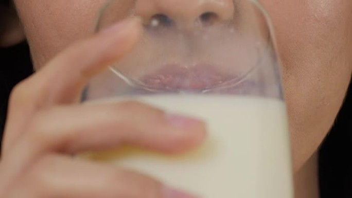 喝牛奶的迷人亚洲女人。特写。
