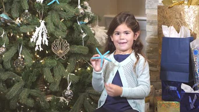 小女孩在圣诞树上悬挂海星